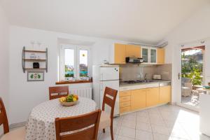 una cocina con una mesa con un bol de fruta. en Olive Trees Cottage en Bol