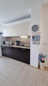 uma cozinha com armários brancos e um lavatório em Green Life Beach Resort- Апартамент Фемили 2 em Sozopol