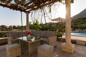 un patio con mesa, sillas y piscina en Olive Trees Cottage en Bol