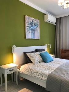 ein Schlafzimmer mit einem Bett und einer grünen Wand in der Unterkunft Apartment Neptun in Warna