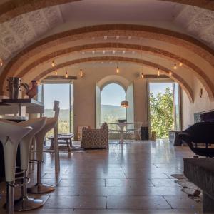 een grote kamer met een stenen vloer en grote ramen bij Siena House in Torrita di Siena