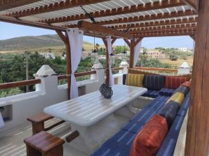 um pátio com uma mesa branca e cadeiras num telhado em Kontoudi's House em Áno Sangríon