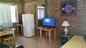 sala de estar con nevera y mesa con TV en La Argentina Complejo, en Villa Ciudad de América