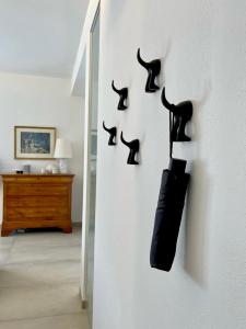 a wall with black cat hooks on a wall at casa prima gardenia in Torri del Benaco