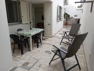 un patio con tavolo e sedie sul cortile di La Meridiana 2 a Marina di Leuca