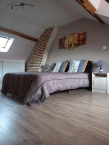 a bedroom with a large bed in a attic at maison chaleureuse solognote mitoyenne in La Ferté-Saint-Aubin