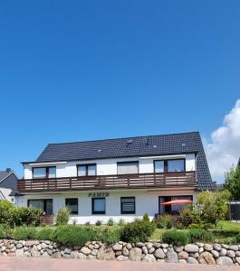 un bâtiment blanc avec un toit noir dans l'établissement Haus Pamir, à Büsum
