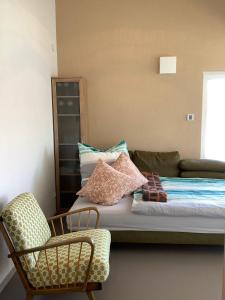 a bed with pillows and a chair in a room at Zeitlos Bodensee in Friedrichshafen