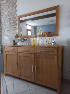 a bathroom with a wooden vanity with a mirror at maison chaleureuse solognote mitoyenne in La Ferté-Saint-Aubin
