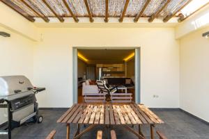een houten bank in een kamer met een grill bij MYRTO Living in luxury and enjoying the view in Ária
