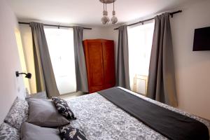 a bedroom with a bed and two large windows at Phiros B&B in Piran