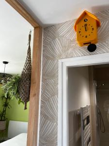 un reloj amarillo en la pared de una habitación en ver(t) chez nous, en Périgueux