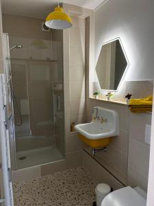 uma casa de banho com um lavatório e um chuveiro em ver(t) chez nous em Périgueux
