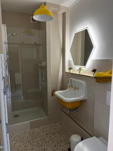 a bathroom with a sink and a shower at ver t chez nous Parking privé ascenseur balcon in Périgueux +11 photos