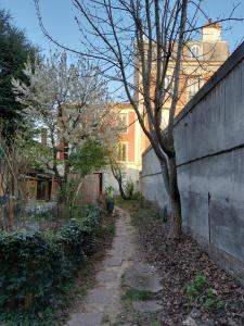 un sentiero sporco vicino a un muro con un albero di F2 Entre Paris et Eurodisney 5 min à pied gare a Le Perreux-sur-Marne