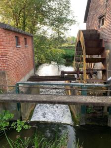 a bridge over a river with a water mill at B&B elzartwinning in Hasselt