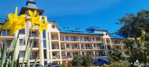 a large building with yellow flowers in front of it at BLUE MARE Apartamenty MES in Łukęcin