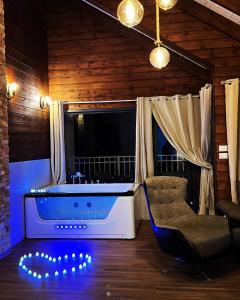 Zimmer mit Badewanne, Stuhl und TV in der Unterkunft ארואד סוויטס Arwad suites in Madschdal Schams