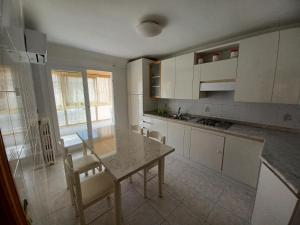 a kitchen with white cabinets and a table and chairs at Appartamento Felicia in San Benedetto del Tronto
