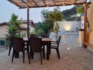 a wooden table and chairs on a patio at Chic Coastal Hill Escape in Ventimiglia