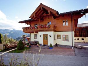 a wooden house with a balcony with flowers on it at Cozy apartment near the ski area in Wagrain