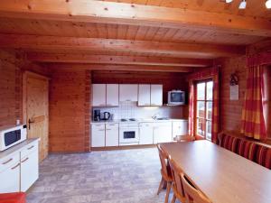 a kitchen with white cabinets and a wooden ceiling at Cozy apartment near the ski area in Wagrain