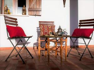 une table de salle à manger avec deux chaises et des coussins rouges dans l'établissement Holiday Home in Guadiana Park near River, à Mértola