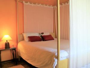 une chambre avec un lit à baldaquin avec des oreillers rouges dans l'établissement Holiday Home in Guadiana Park near River, à Mértola