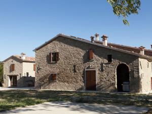 una antigua casa de piedra con una puerta grande y un edificio en Appealing apartment in Modigliana with garden, en Tredozio