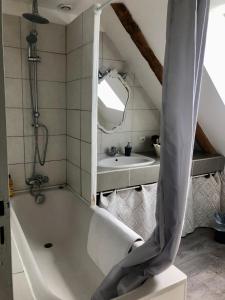 a bathroom with a bath tub and a sink at Chambre double avec SDB privée au milieu des champs in Teloché