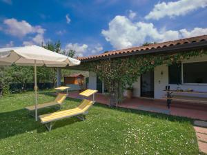 un patio con 2 sillas y una sombrilla en Modern Holiday Home in San Feliciano with Private Terrace, en San Feliciano