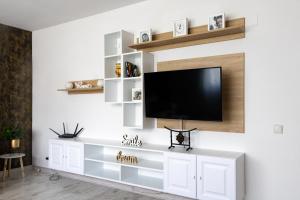 Una sala de estar con un televisor de pantalla plana en una pared. en Cozy Apartments, en Timisoara