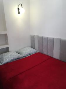 a bedroom with a bed with a red blanket at ComeWa Apartments in Warsaw