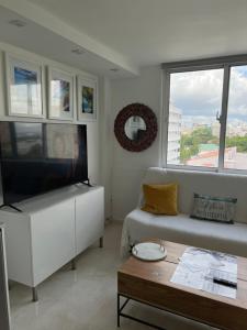 sala de estar con sofá, TV y mesa en Yoa’s escape en San Juan