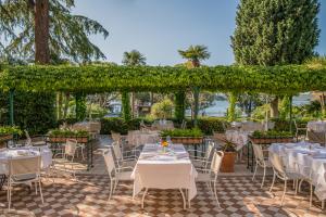 a restaurant with white tables and chairs and a pergola at Hotel Marko in Portorož