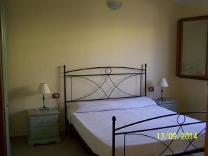 1 cama en un dormitorio con 2 mesitas de noche y 2 lámparas en Villa Julia, en Tertenìa