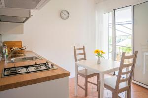 a kitchen with a sink and a table with chairs at ALOE - Villa Luisa: Pace e Relax a 2 passi dal mare in Casarza Ligure