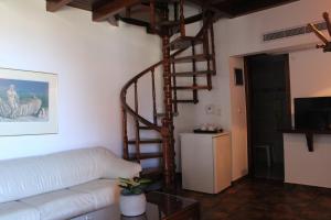 salon z kanapą i spiralnymi schodami w obiekcie Candia House w mieście Kandia