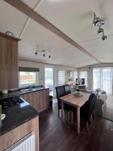 a kitchen and dining room with a table and chairs at Norfolk Caravan Staycation Pet Friendly in Belton