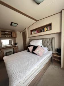 a bedroom with a white bed with two pillows on it at Norfolk Caravan Staycation Pet Friendly in Belton