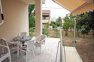 een patio met een tafel en stoelen op een veranda bij HOUSE - Apartman SARAH in Kaštela