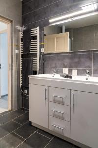 a bathroom with a white sink and a mirror at Németh Apartman in Keszthely