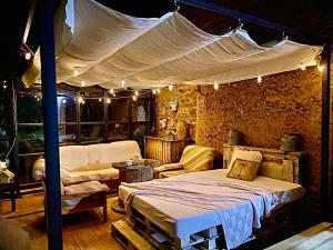 a bedroom with a bed with a canopy and a couch at Casa Rural Pico del Lugar in Villar de los Barrios