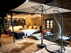 a living room with an umbrella and a swing at Casa Rural Pico del Lugar in Villar de los Barrios