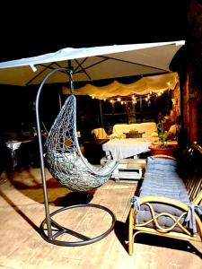 eine Hängematte und ein Stuhl unter einem Sonnenschirm in der Unterkunft Casa Rural Pico del Lugar in Villar de los Barrios