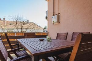 a wooden table and chairs on a balcony at Németh Apartman in Keszthely