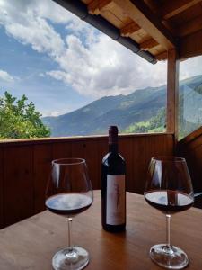 a bottle of wine and two wine glasses on a table at Ferienwohnungen Alpenblick Vierbauch in Flattach