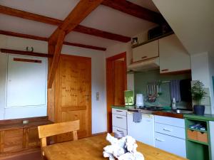 a kitchen with a wooden table and a wooden ceiling at Ferienwohnungen Alpenblick Vierbauch in Flattach