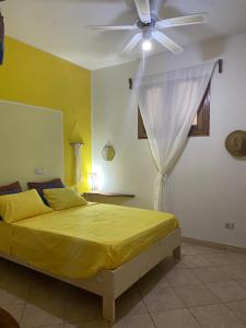 a bedroom with a yellow bed and a ceiling fan at Casa Carlotta - 100m from the Beach, Maio in Vila do Porto +147 photos