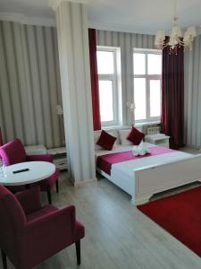a bedroom with a bed and a table and chairs at Apart Hotel Триумф Астаны 22 этаж, Секция 2 in Astana